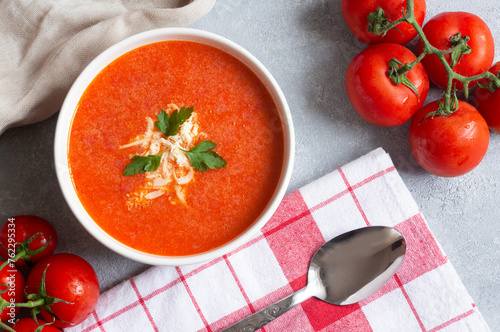Tomato soup in bowl with fresh organic tomatoes on table, healthy homemade traditional soup	
