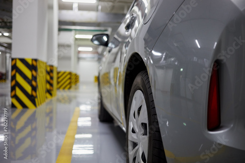 Left side of car metallic on parking place at underground parking.