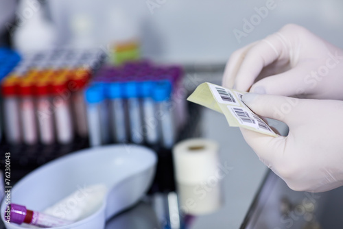Laboratory assistant hands hold stickers with bar codes, shallow dof.