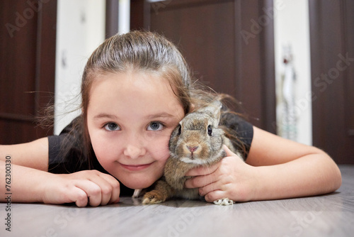 Принти на полотні Little girl lies with rabbit on floor in flat.