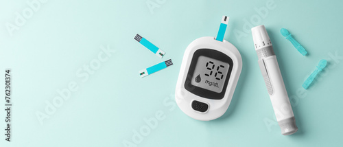 Blood glucose meter, diabetes checking sugar level on light green background photo