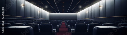 Modern empty cinema auditorium with red carpet and black leather seats