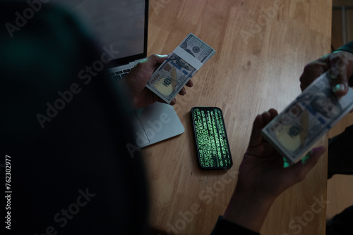 Unknown Hooded Online Criminal with cash. photo