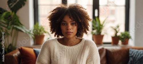 Beautifulyoung black woman relaxing on sofa in her apartment.