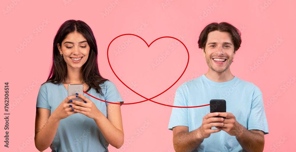 A young woman in a light blue top smiles at her phone, while a man in a white shirt looks at his A young woman in a light blue top smiles at her phone, while a man in a white shirt looks at his