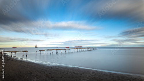 Serene seascape with long pier under a dynamic sky