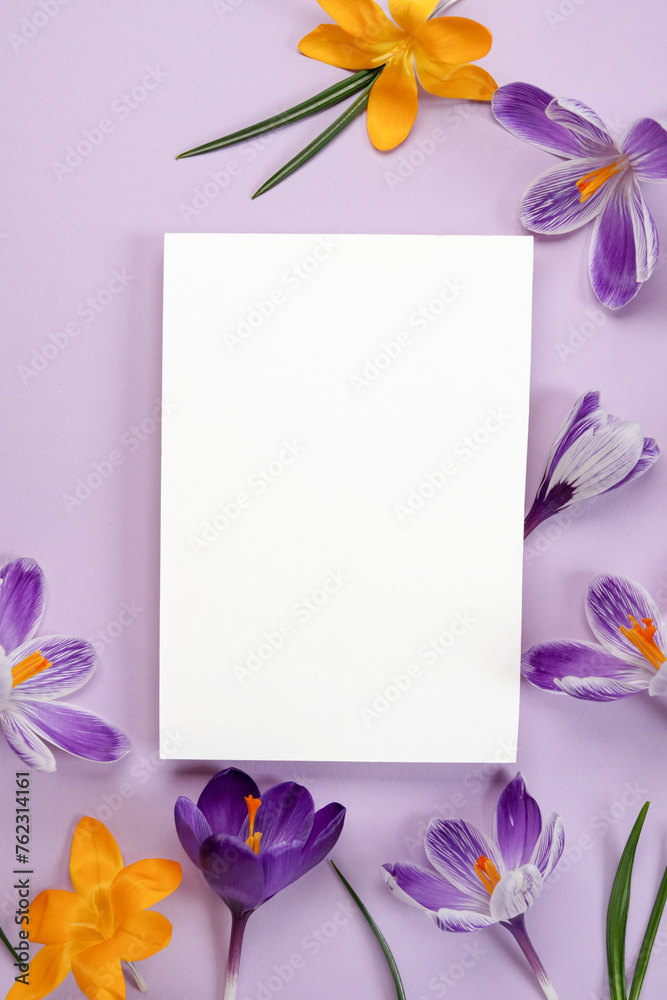 Spring flowers pattern. Frame of violet and yellow crocuses with paper blank. Top view, flat lay, banner. Space for text. Festive floral background.