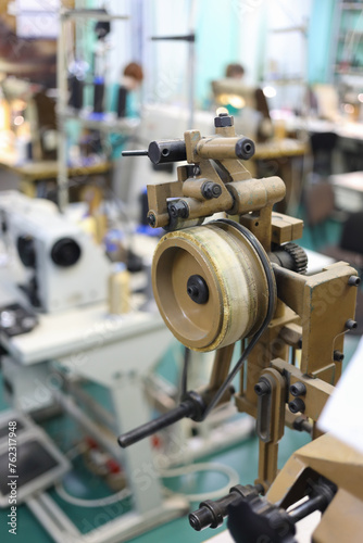 Belt drive at sewing machine for sewing shoes in workshop of shoes factory