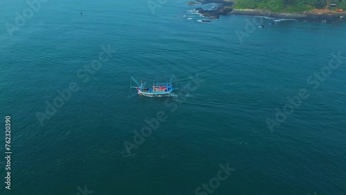 Aerial cinematic footage of Vietnamese fishermen's fishing boat running on the sea in the morning.