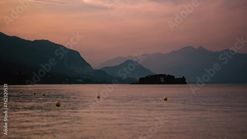 Orange sunset timelapse of Isola Bella on Maggiore Lake Italy - Boats passing  (ID: 762320531)