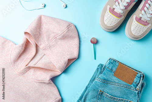 Clothes for youth on a blue background. Outfit for teenagers. Top view, flat lay.