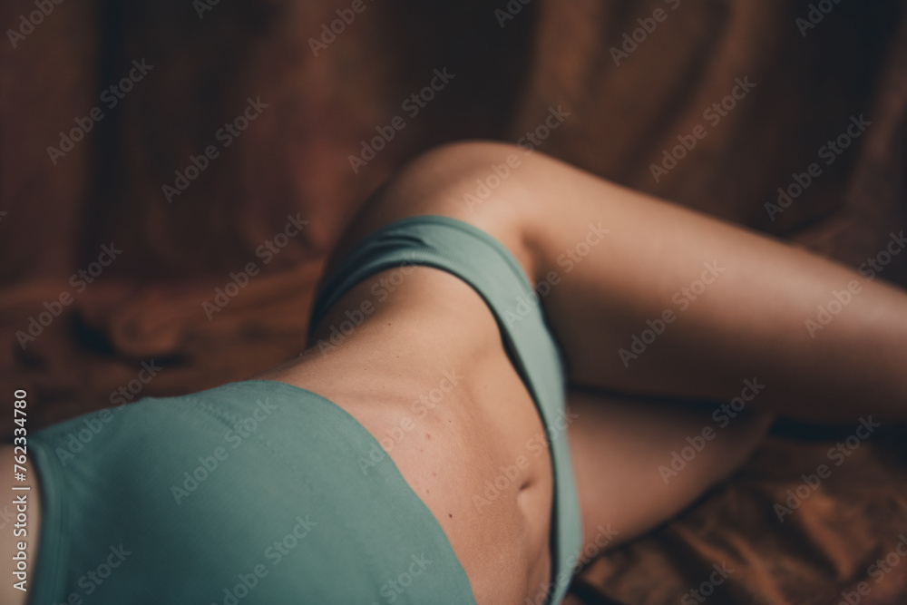 Photo of perfect model young female in khaki top and panties laying down slim body stomach hips isolated over brown textile background - obrazy, fototapety, plakaty 