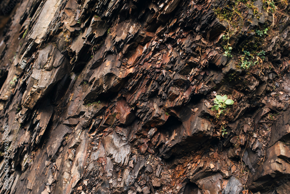 Uneven, rough stone texture, retractable rock close-up. Natural background for design. Front view Uneven, rough stone texture, retractable rock close-up. Natural background for design. Front view