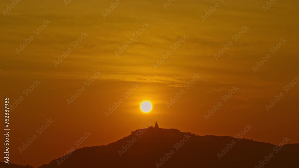 Yellow sky over the Phuket Big Buddha in sweet sunset..Phuket big Buddha is the famous landmark..360 degree view on Phuket big Buddha viewpoint. orange sky of sunset background Yellow sky over the Phuket Big Buddha in sweet sunset..Phuket big Buddha is the famous landmark..360 degree view on Phuket big Buddha viewpoint. orange sky of sunset background