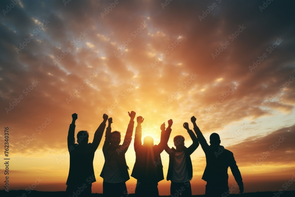A group of people raising their hands in the air. Suitable for team building concept