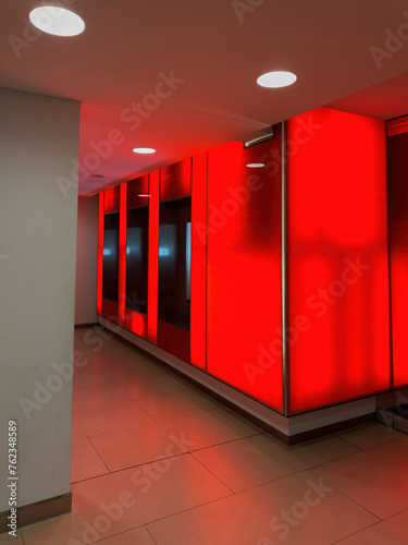 A corridor bathed in red light creates a dramatic and modern atmosphere inside a building.