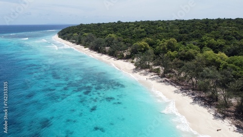 Scenic aerial view of Jaco Island with crystal clear turquoise ocean water, white sandy beach and forest trees on remote uninhabited tropical island © Adam Constanza