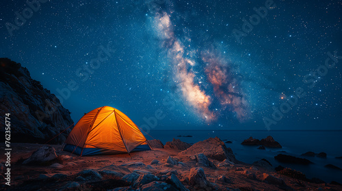 Beautiful night landscape with a wooden house on the top of the mountain. Camping on the beach. Night sky with stars and milky way.