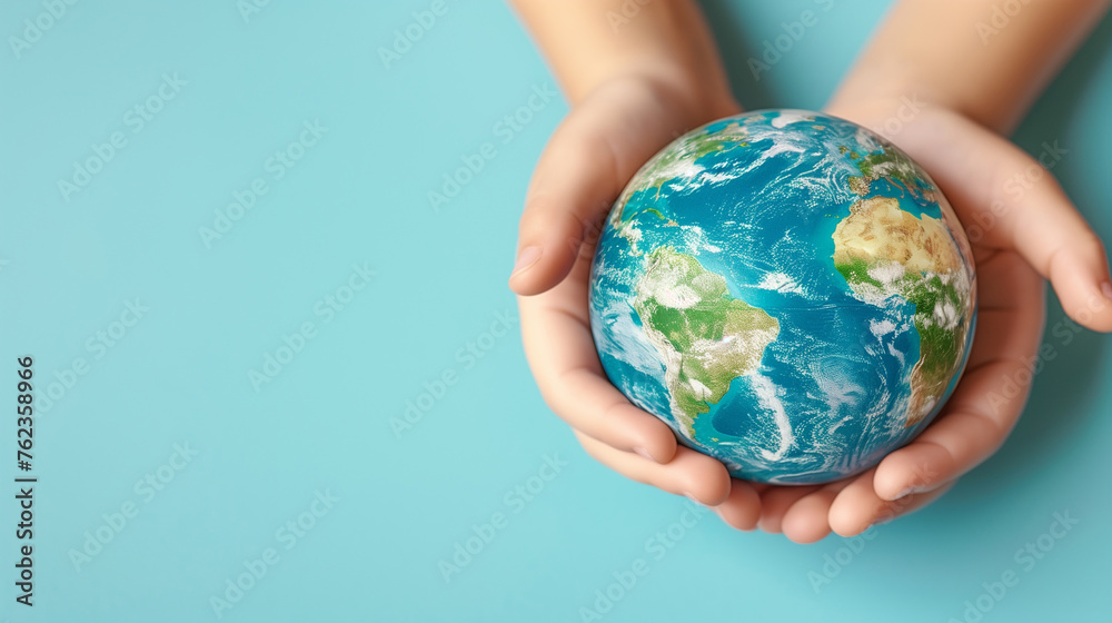 Earth globe planet in kid's tender hands against blue background with copy space. World environment day, Earth world protection concept. Earth globe planet in kid's tender hands against blue background with copy space. World environment day, Earth world protection concept.
