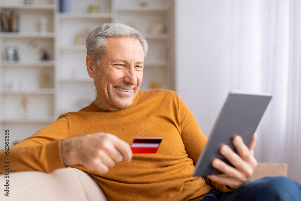 Mature man shopping online with tablet and card Mature man shopping online with tablet and card