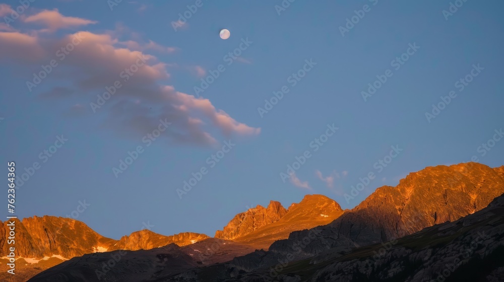 Naklejka premium Moonrise over Rugged Mountain Peaks