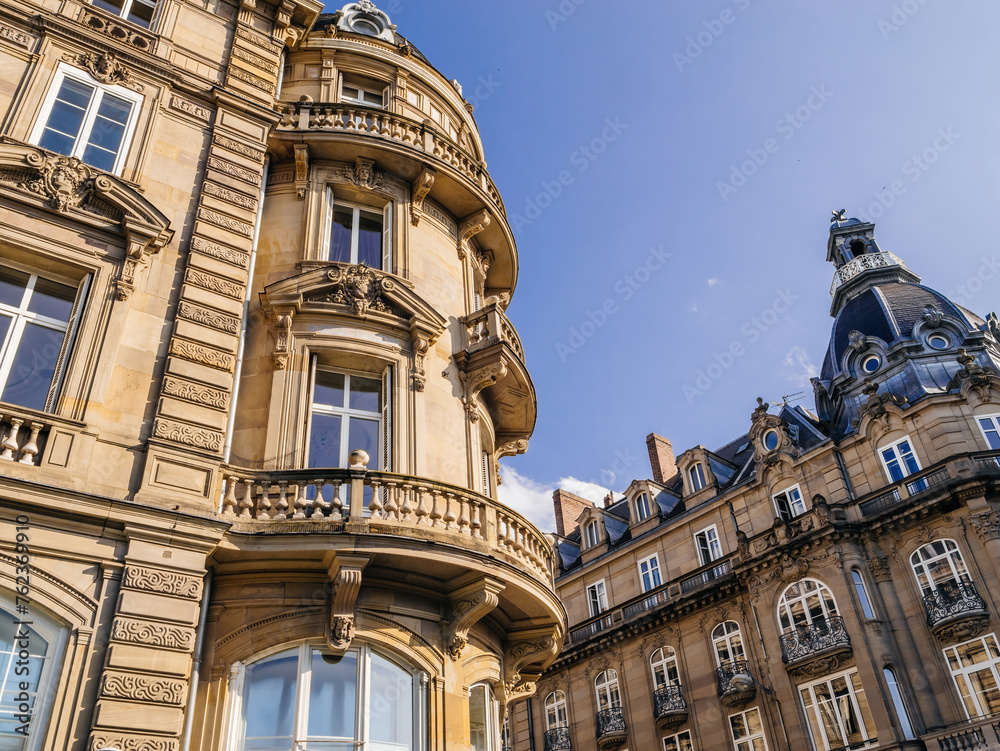 An opulent facade with ornate balconies epitomizes luxury investment in real estate, set against a clear, vast sky