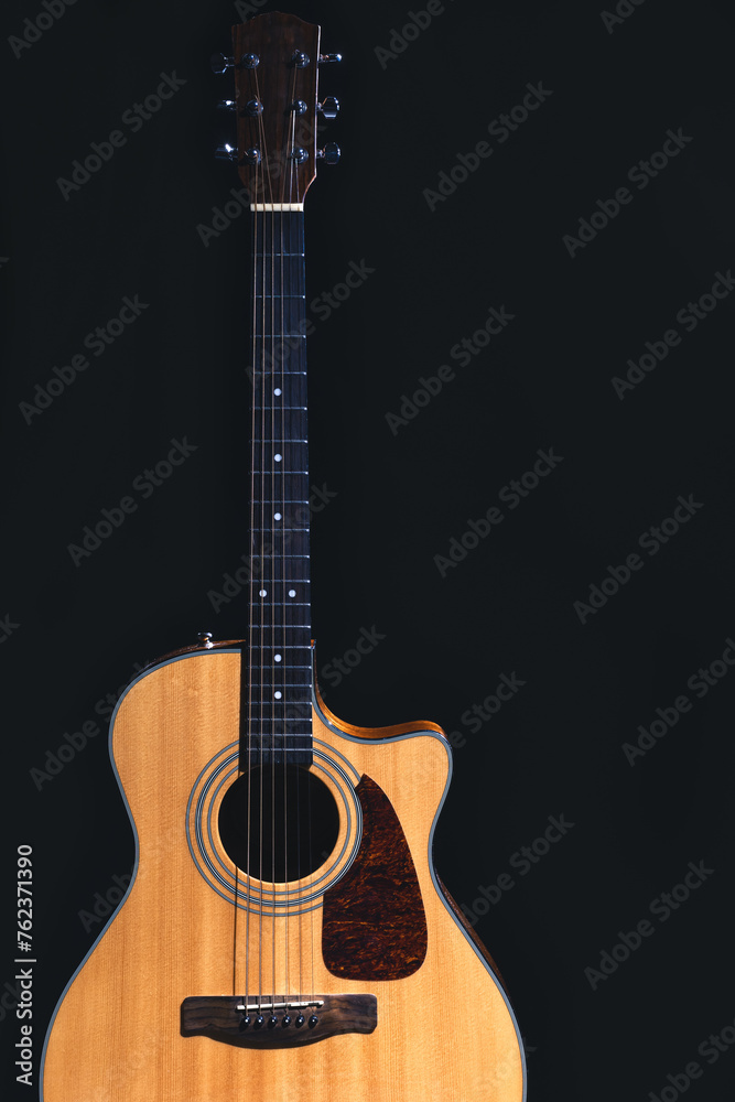 Fototapeta premium Acoustic guitar on a black background, flat lay.