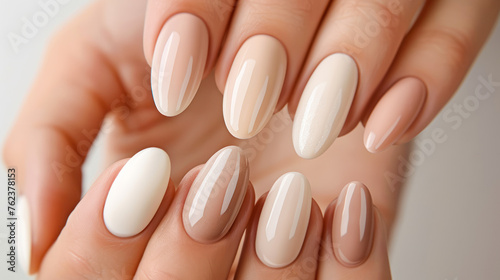 Beautiful nude manicure. Long almond shaped nails. Nail design. Manicure with gel polish. Close-up of the hands of a young woman with a gentle nude manicure on her nails. Bright nails with gel polish.