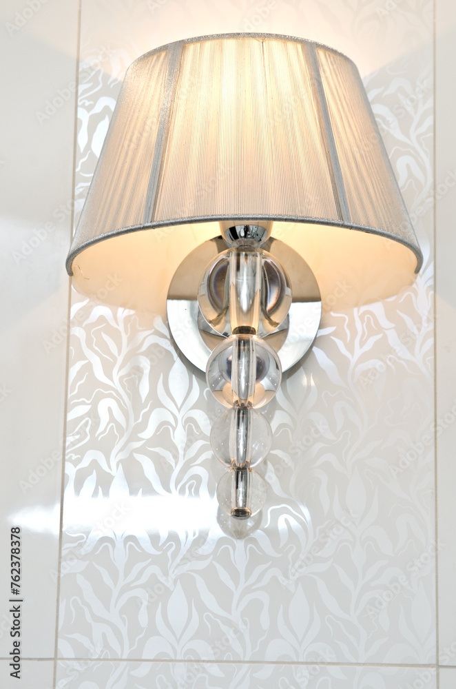 Elegant classic style lamp as a bathroom decoration detail. Warm light.