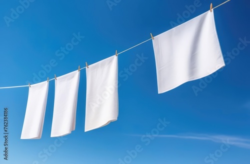 snow-white towels dry on a rope against a blue sky background