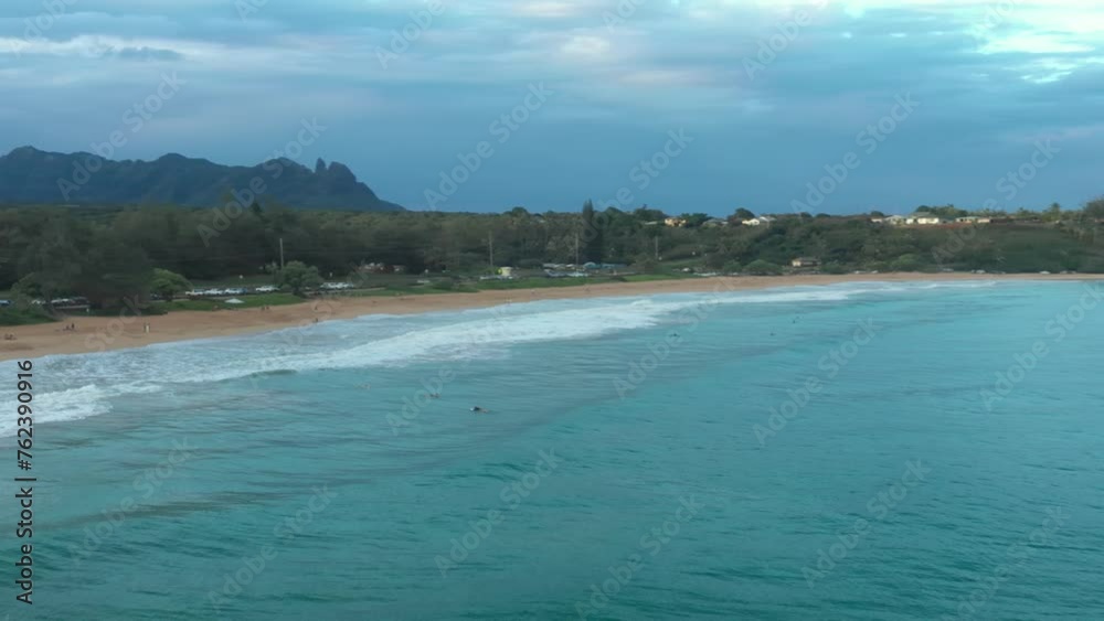 Aerial video of surfers on the beach on the island of Kauai Hawaii, at sunset Aerial video of surfers on the beach on the island of Kauai Hawaii, at sunset