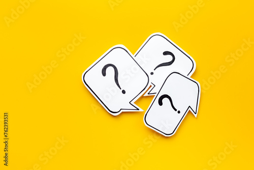 Question marks on paper speech bubbles, top view. Ask and answer concept