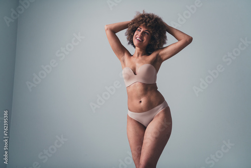 Unretouched photo of smiling girl look empty space feel body self confidence isolated over pastel color background © deagreez