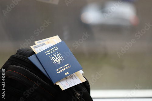 Two ukrainian biometrical passports with air flight tickets on black touristic backpack close up