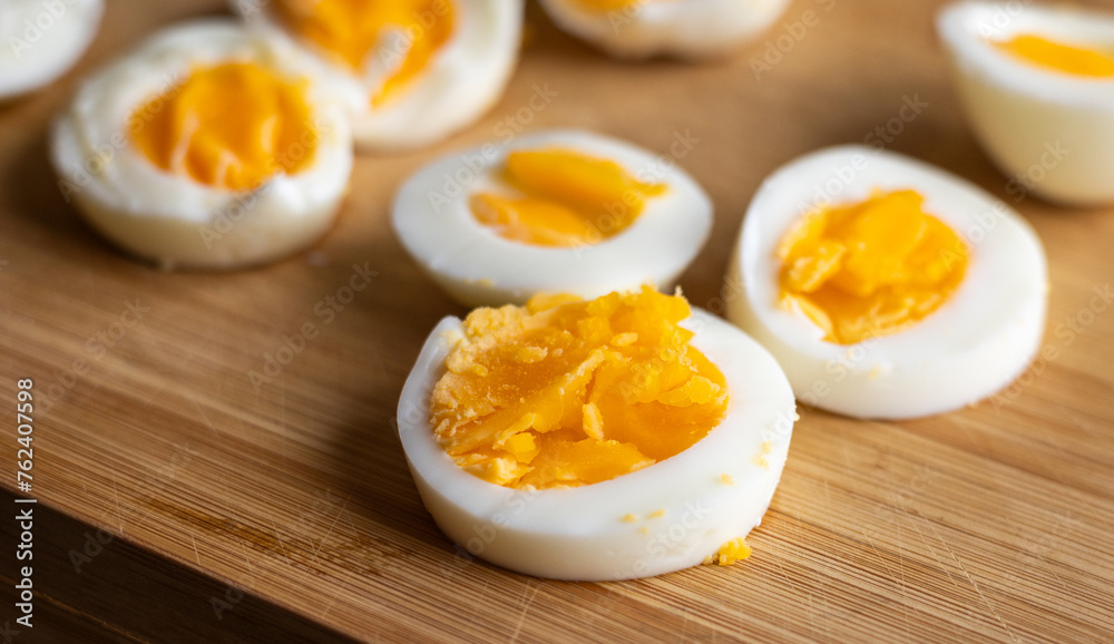Close-up of sliced boiled eggs arranged neatly on a wooden cutting board Close-up of sliced boiled eggs arranged neatly on a wooden cutting board