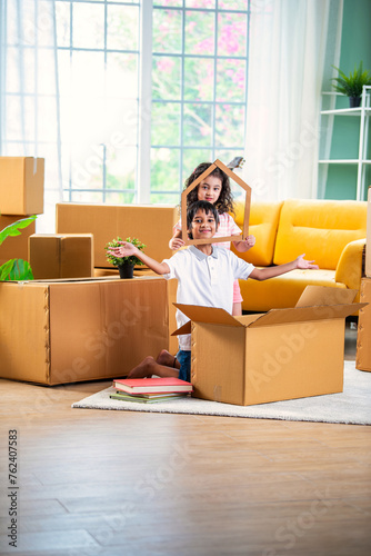 Fotografi Indian siblings or kids playing or opening cardboard cartons on shifting or movi