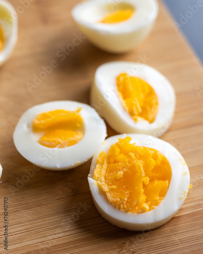 Close-up of sliced boiled eggs arranged neatly on a wooden cutting board