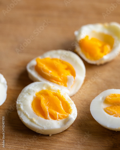 Close-up of sliced boiled eggs arranged neatly on a wooden cutting board