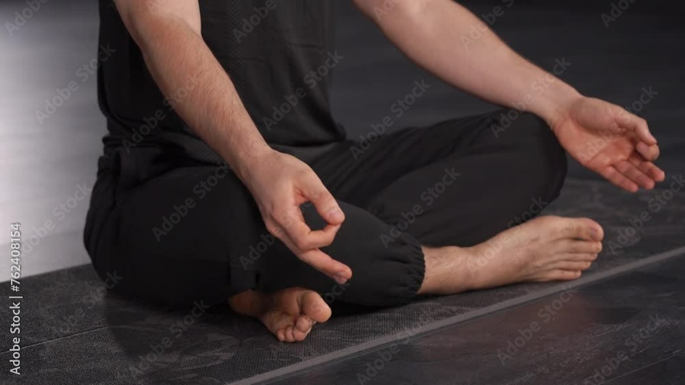 Close-up of a man demonstrating the connection between breathing practices and emotional regulation. man in lotus position, face not visible Close-up of a man demonstrating the connection between breathing practices and emotional regulation. man in lotus position, face not visible
