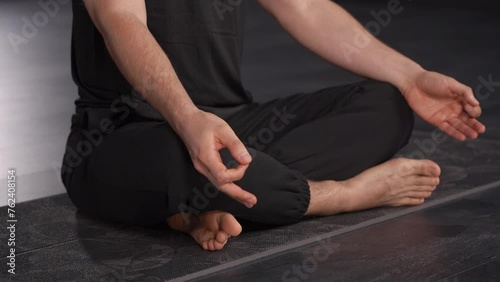 Close-up of a man demonstrating the connection between breathing practices and emotional regulation. man in lotus position, face not visible
