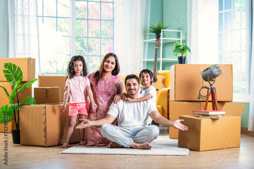 Happy Indian family unpacking boxes at new home