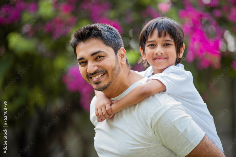 Indian young father carrying his son in the park Indian young father carrying his son in the park