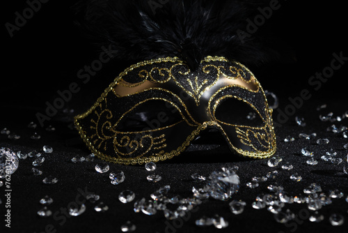 Carnival gold mask with diamonds on black background.