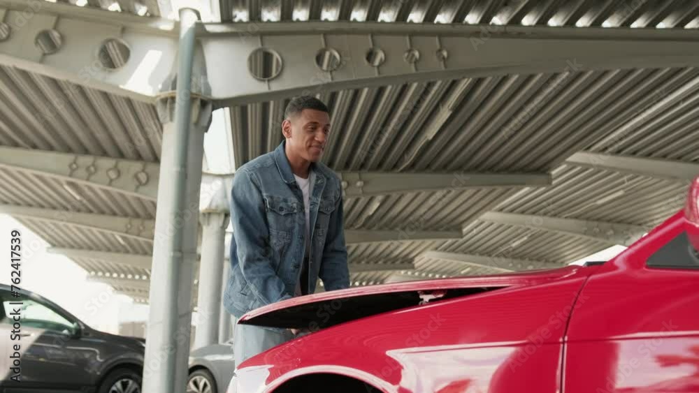 Male driver opening car hood on the parking in the city. Slow motion Male driver opening car hood on the parking in the city. Slow motion