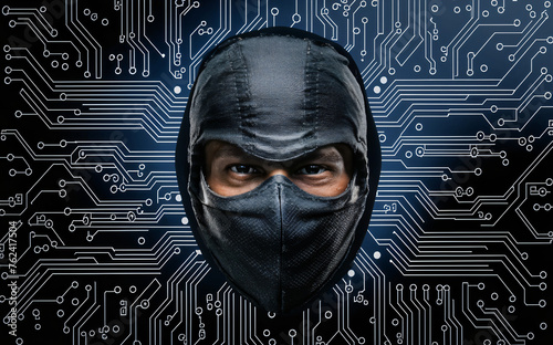Hacker masked embedded in computer printed circuit board metaphor