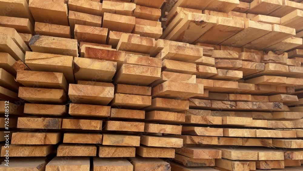 Stacked Timber Planks at a Lumberyard Awaiting Transportation. Stacked wooden planks in varying shades of brown at a timber storage facility. Stacked Timber Planks at a Lumberyard Awaiting Transportation. Stacked wooden planks in varying shades of brown at a timber storage facility.