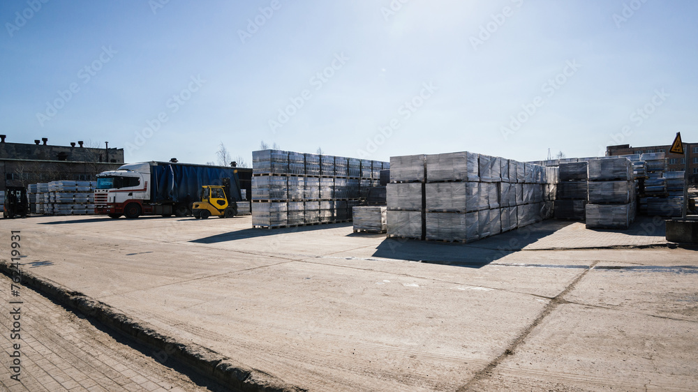  The loading bay is filled with trucks waiting to be loaded with the heavy pallets of finished goods and materials.