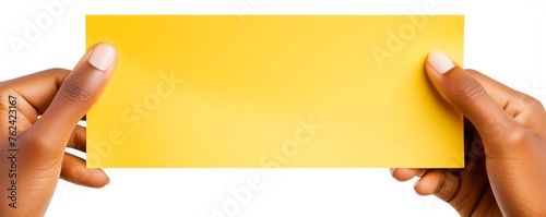 A hand holding a yellow paper isolated on white background