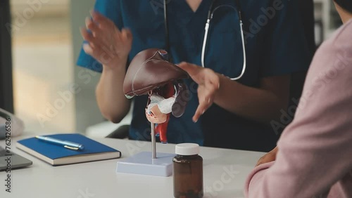 Gastroenterologist doctor explaining liver and gallbladder problems using anatomical model to patient during clinic visit. Treatment of gallbladder and liver diseases photo