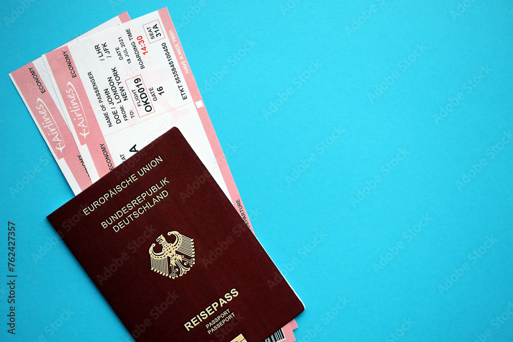 Red German passport of European Union with airline tickets on blue background close up. Tourism and travel concept Red German passport of European Union with airline tickets on blue background close up. Tourism and travel concept